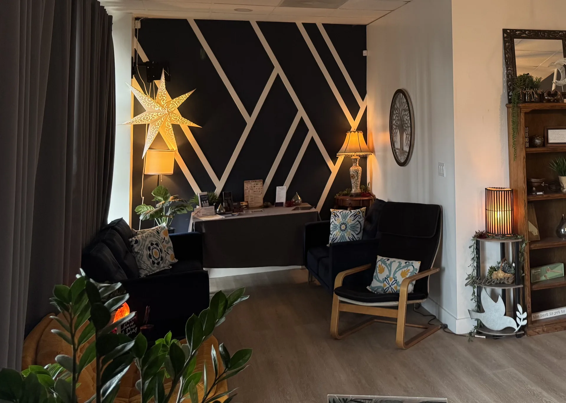 Infrared Sauna Studios waiting area with geometric accent wall, velvet seating, and warm pendant lighting